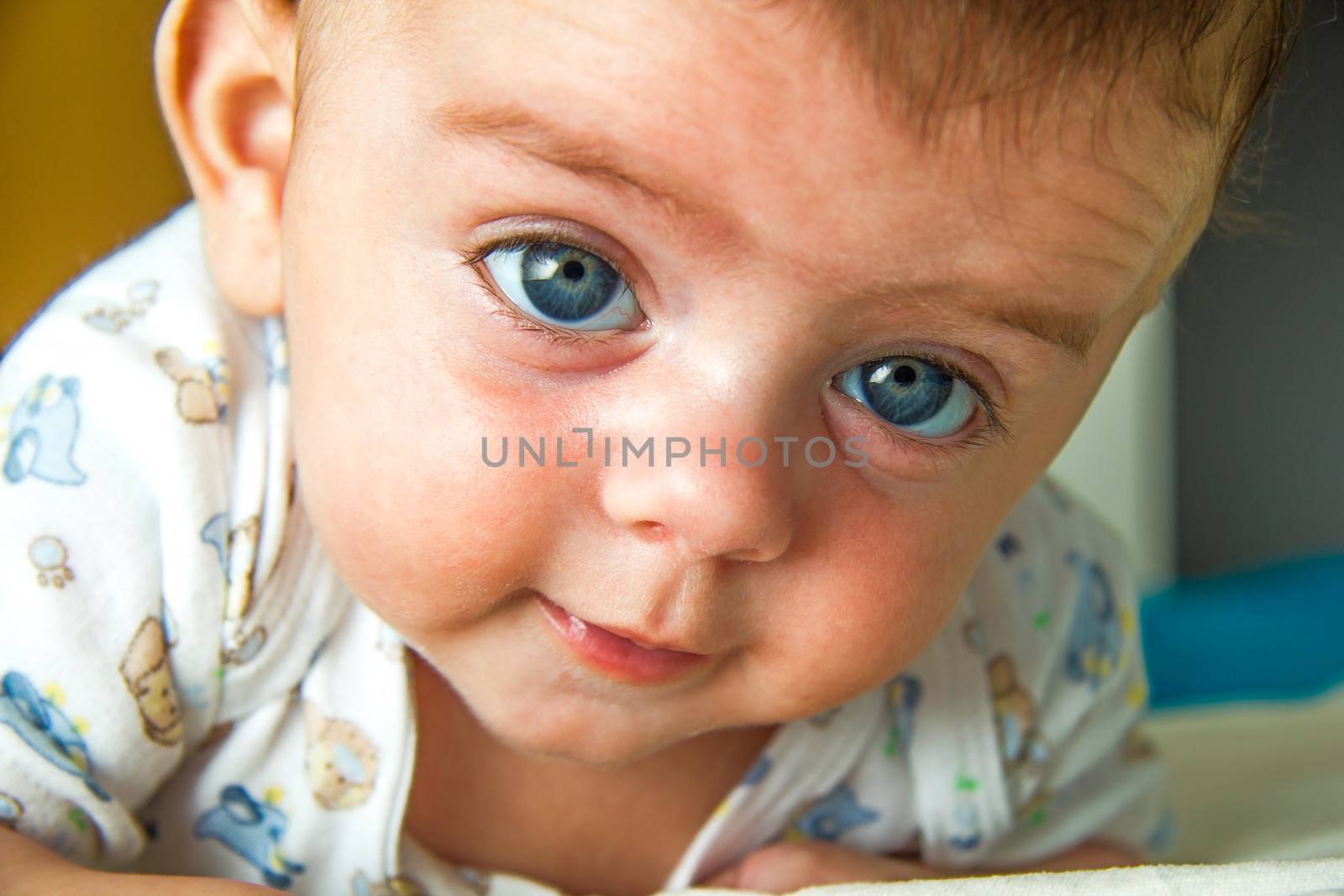 Cute blue eyed baby raising his head