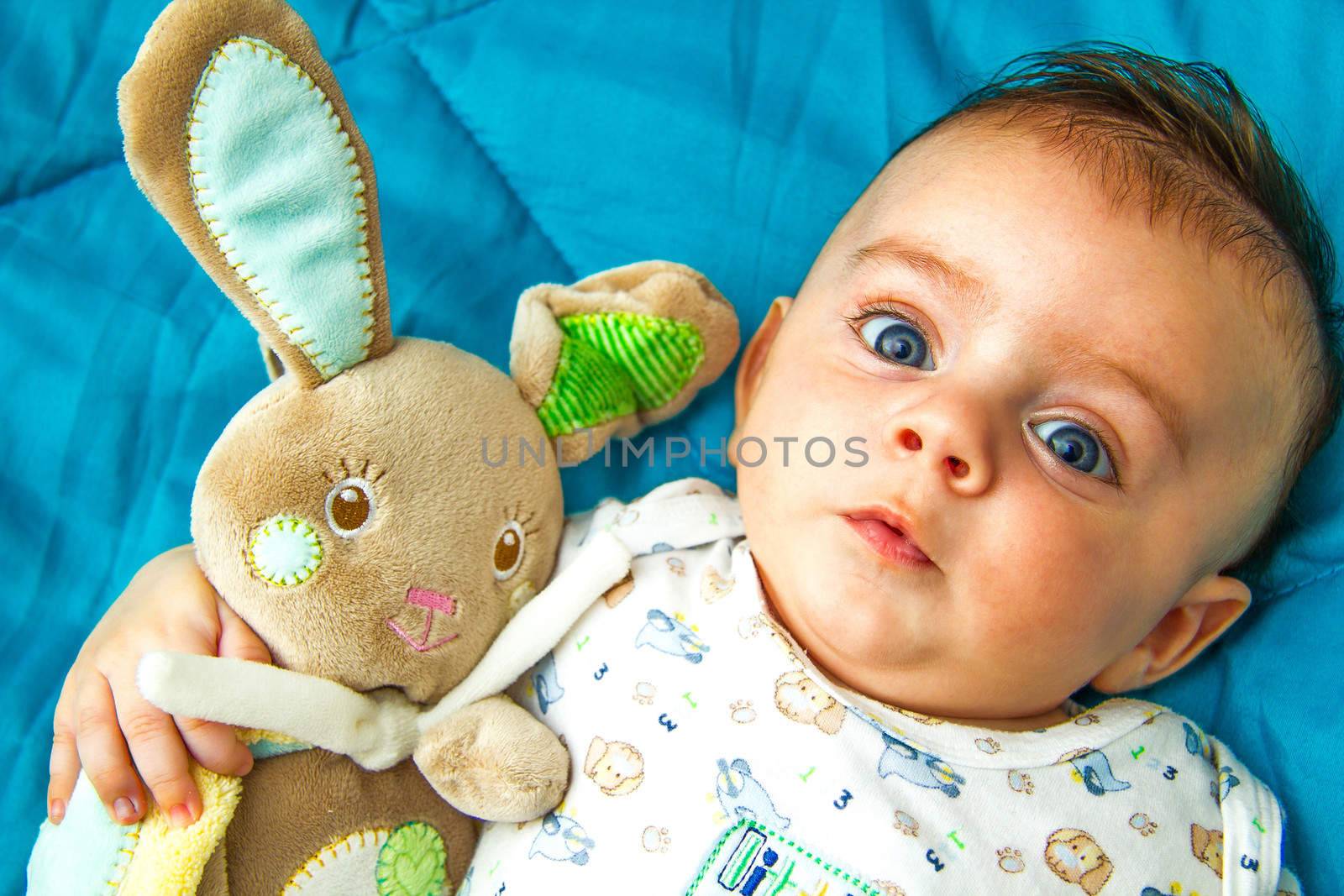 Cute blue eyed baby holding his favorite toy