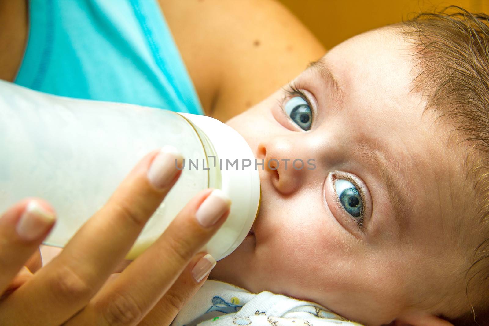 Mother giving milk in a bottle to her baby