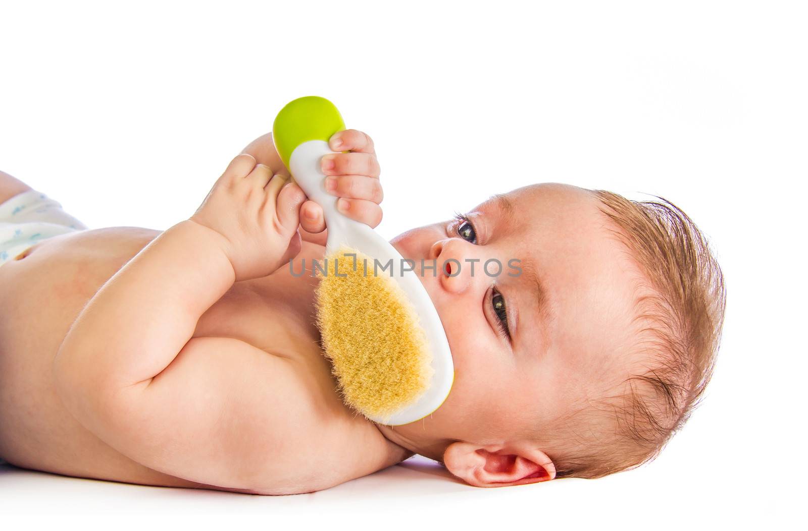 Cute baby holding an hairbrush on white