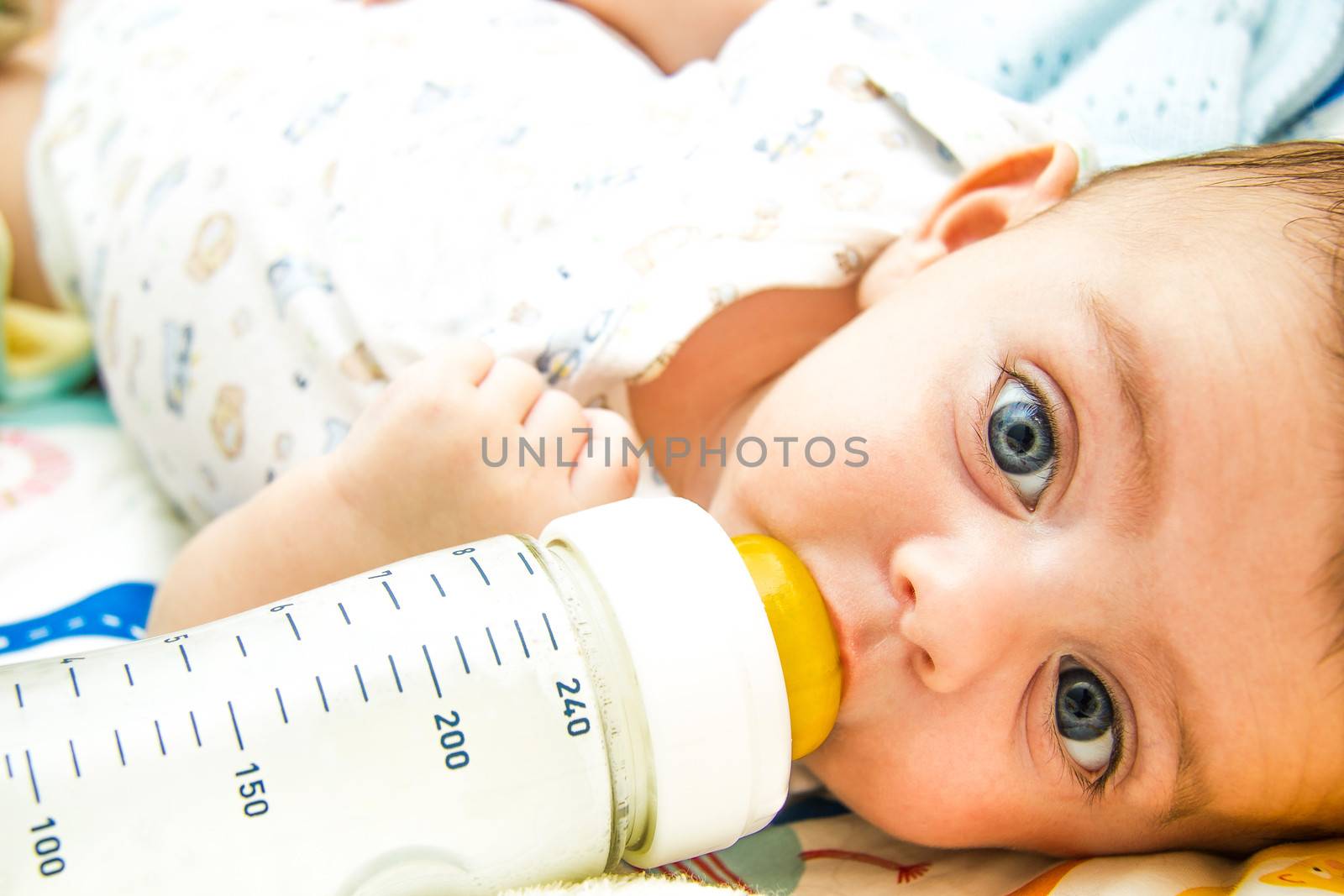 Lovely baby feeding on milk bottle