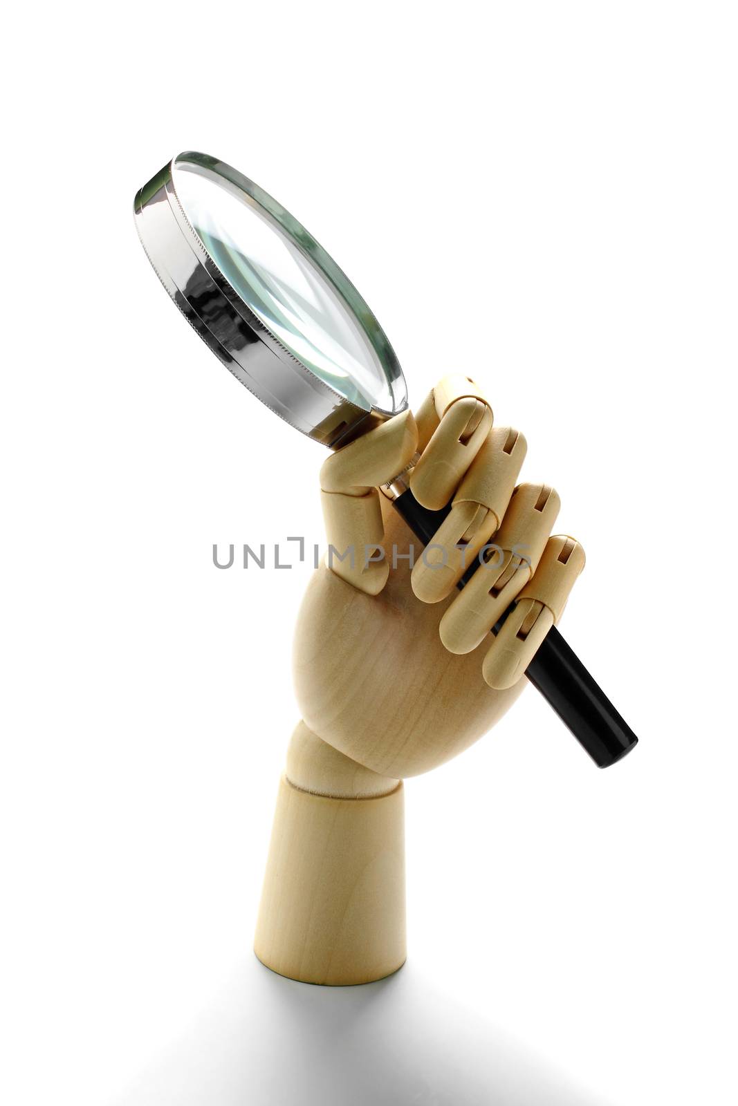 Wooden hand holding a magnification glass over white background