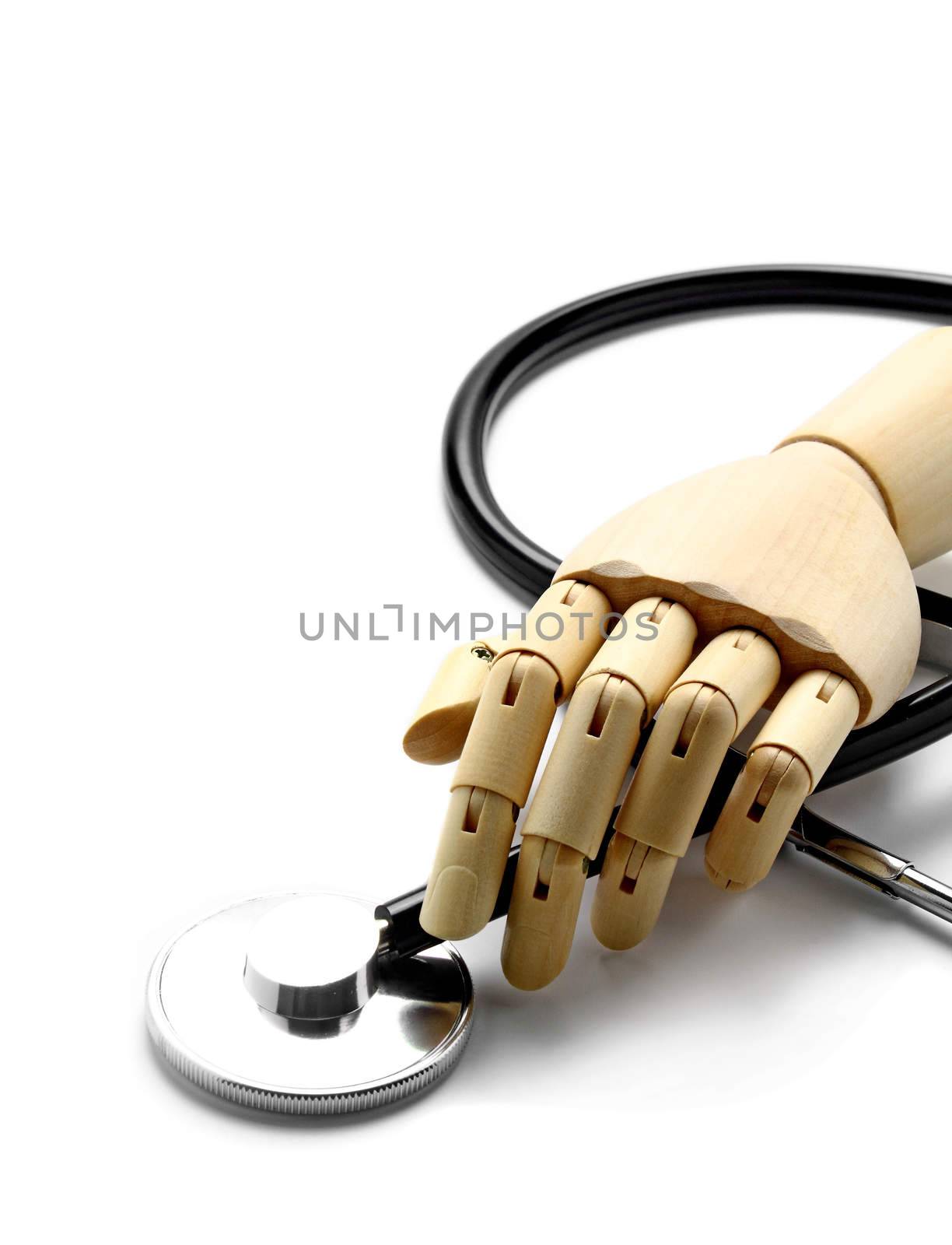 Stethoscope and wooden hand on white
