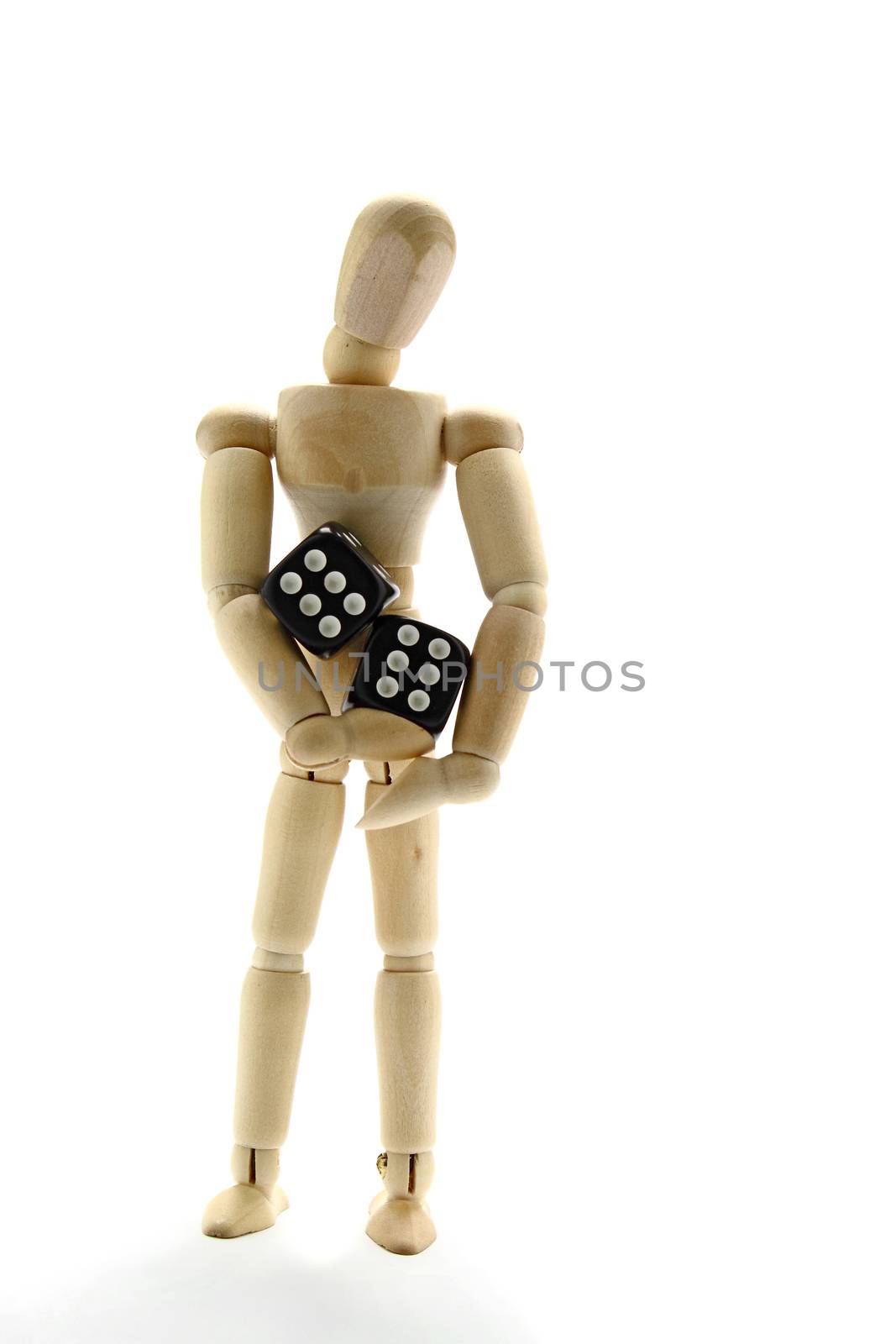 Wooden manikin holding dice on white background