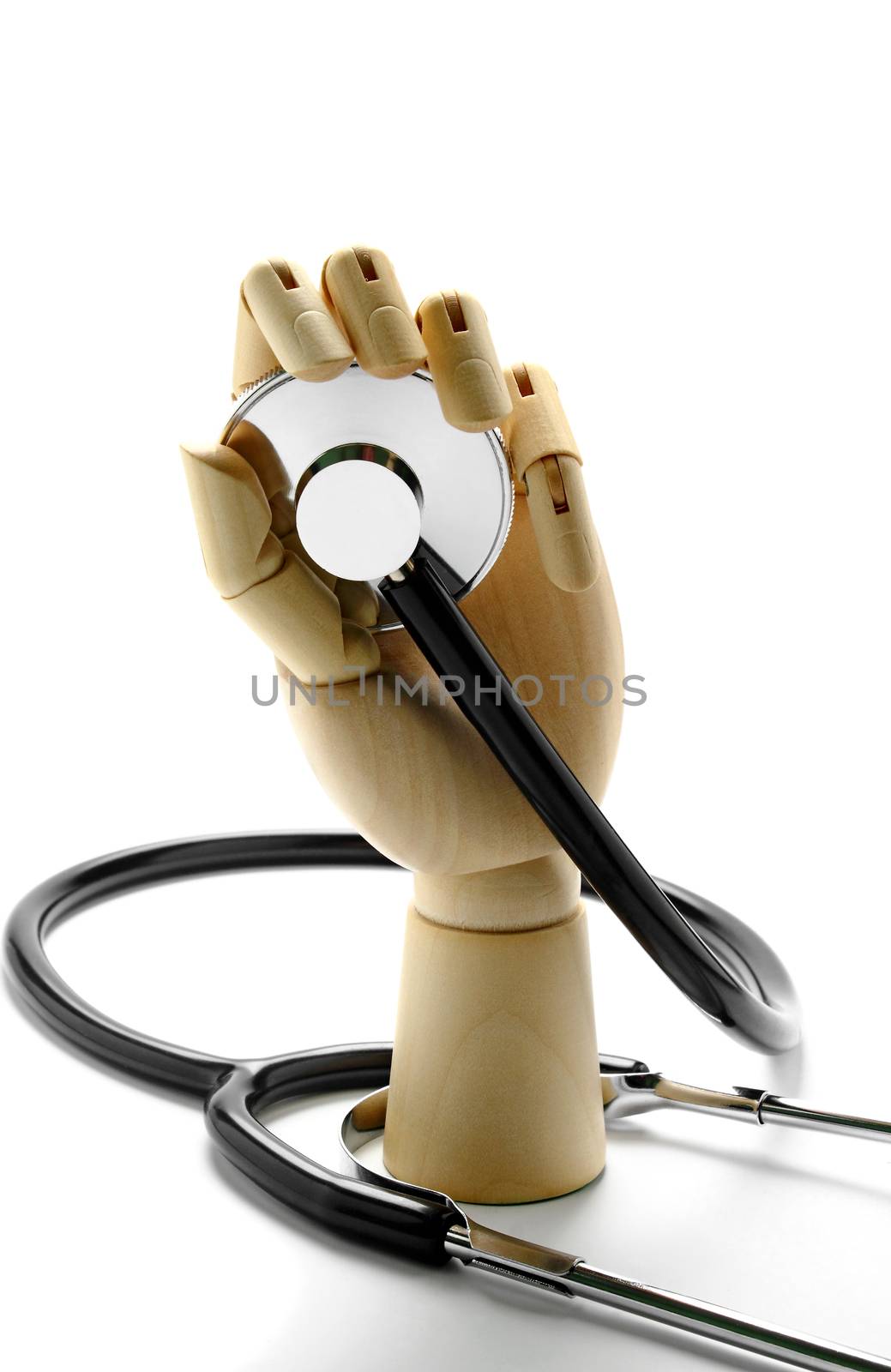 Stethoscope and wooden hand on white