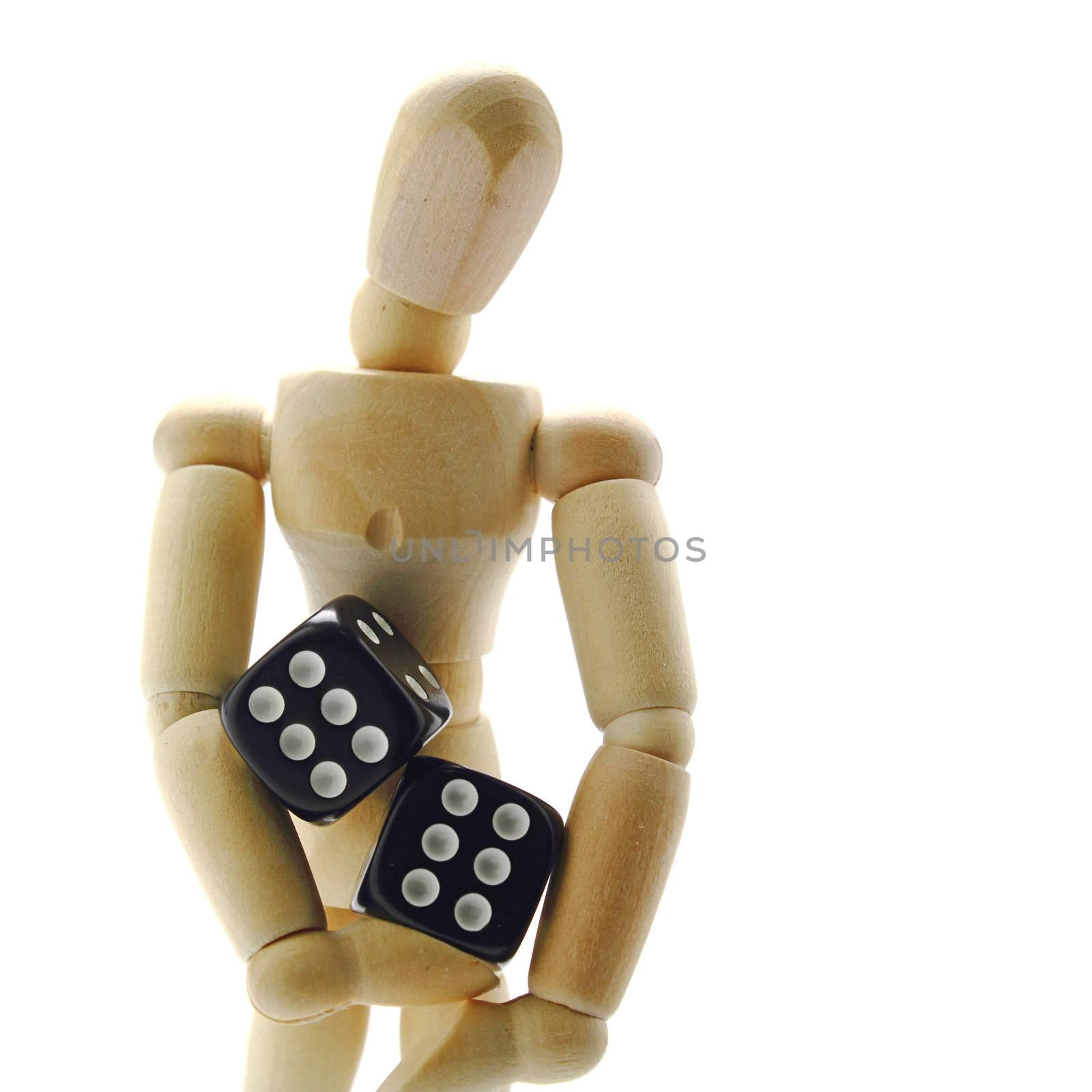 Wooden manikin holding dice on white background