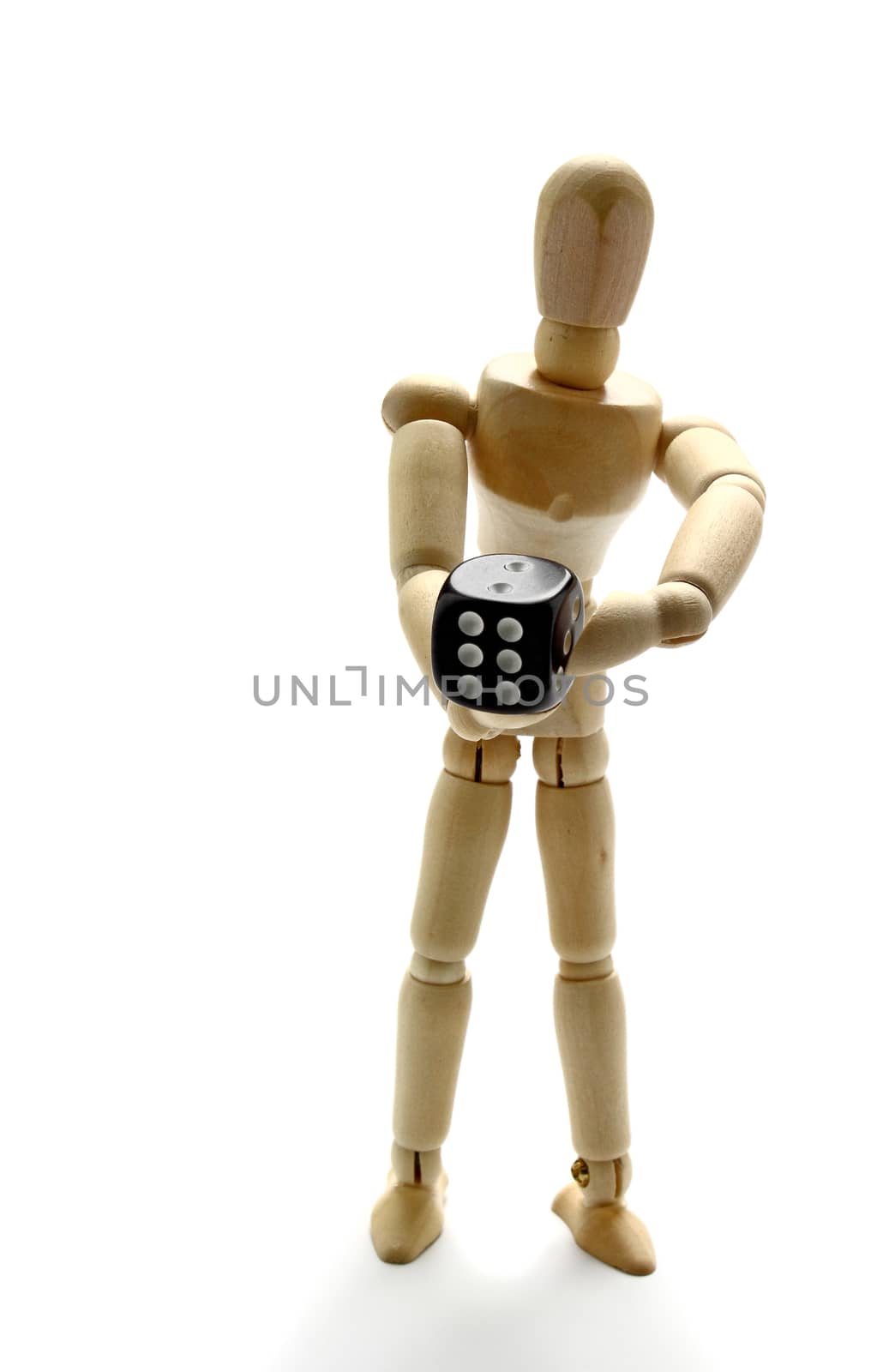 Wooden manikin holding dice by dynamicfoto