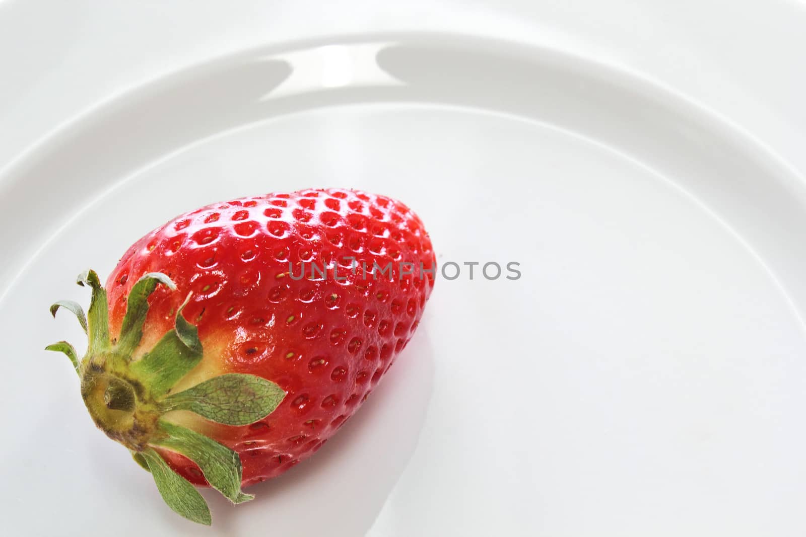 One strawberries over a white dish