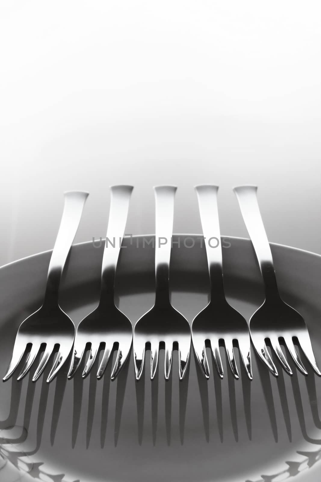 Background of five forks aligned over a dish