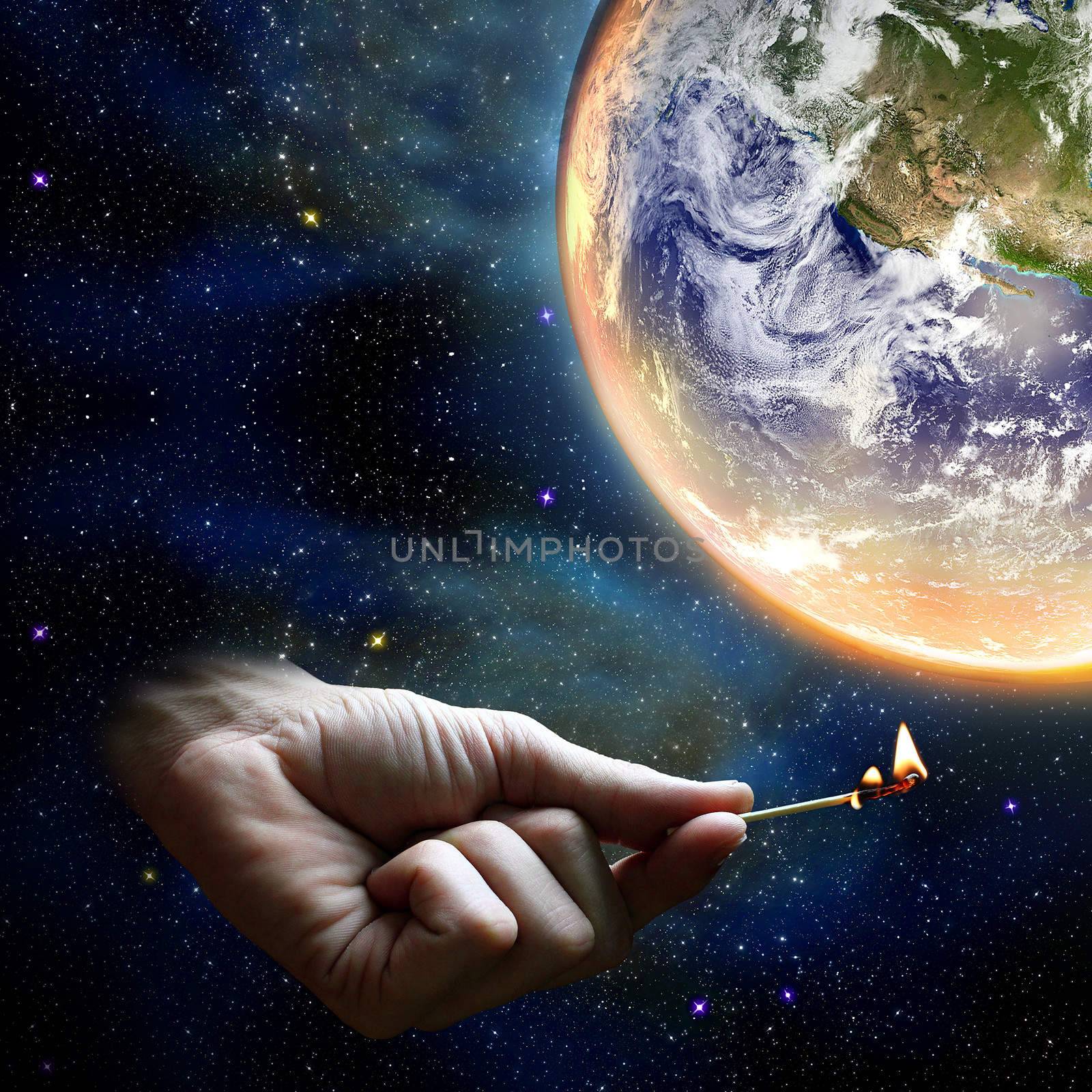 Hand holding a match and the planet earth warming up