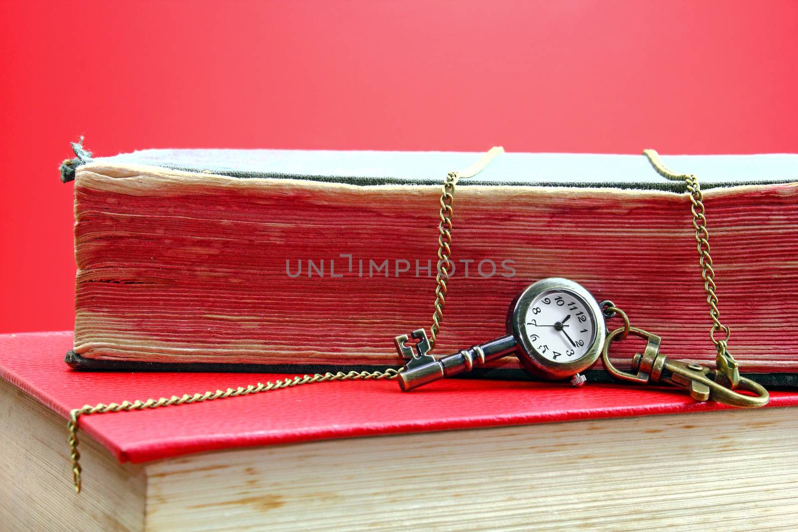 Golden key with a clock over old books