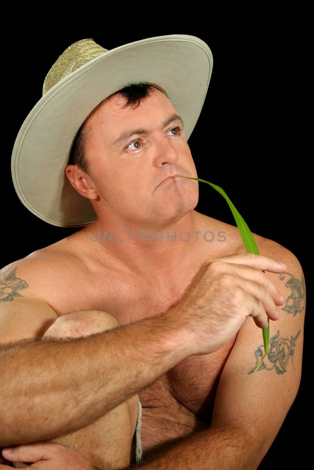 Bare chested country boy with blade of grass.