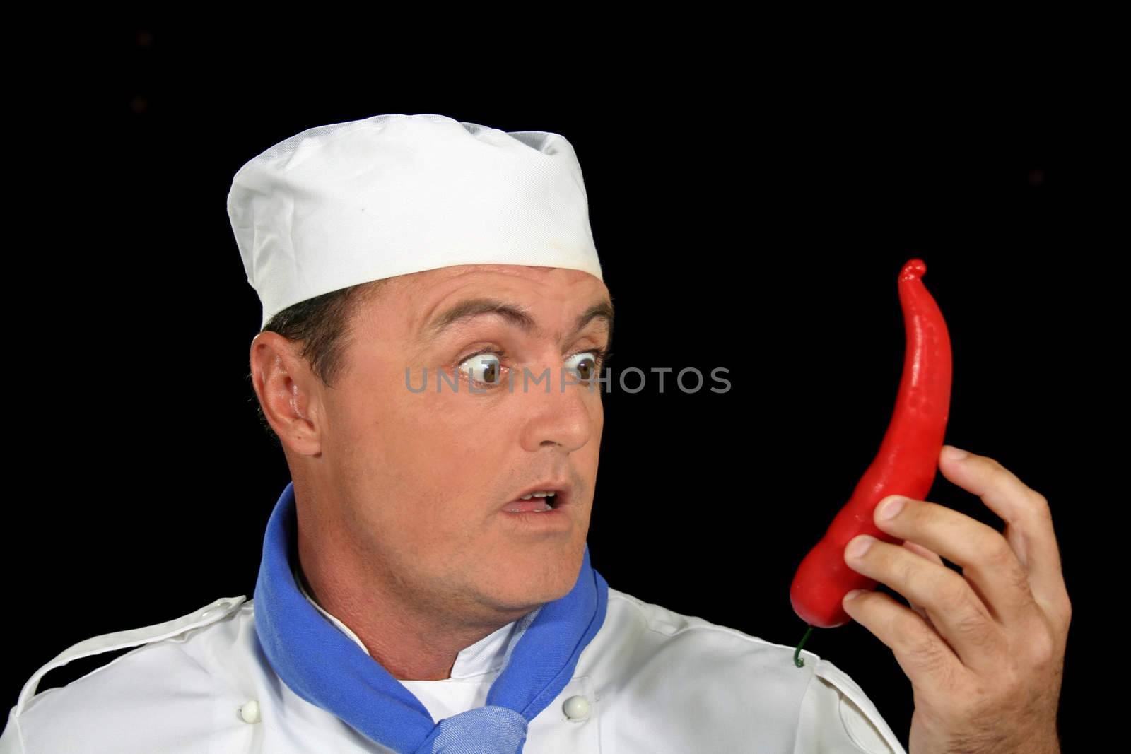 Surprised chef with a giant chili pepper.