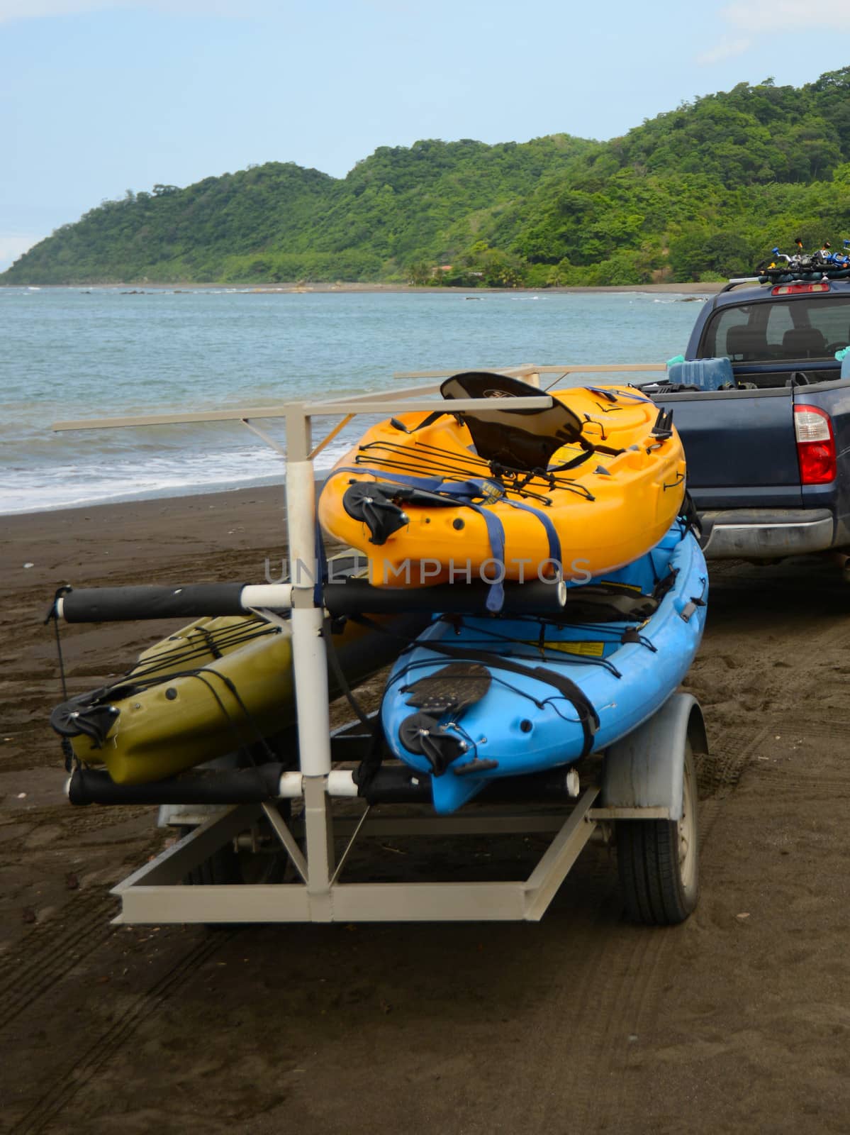 kayaks being pulled up to ocean on trailer and a truck