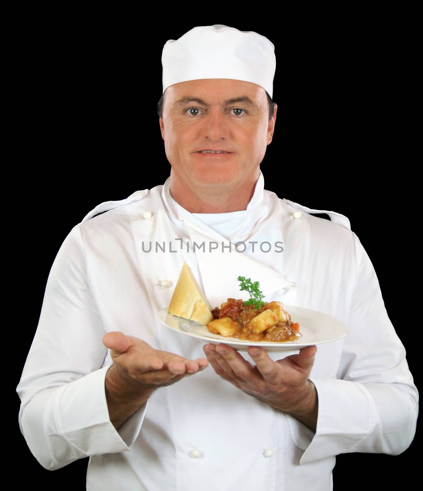 Chef presents freshly cooked meal to camera.