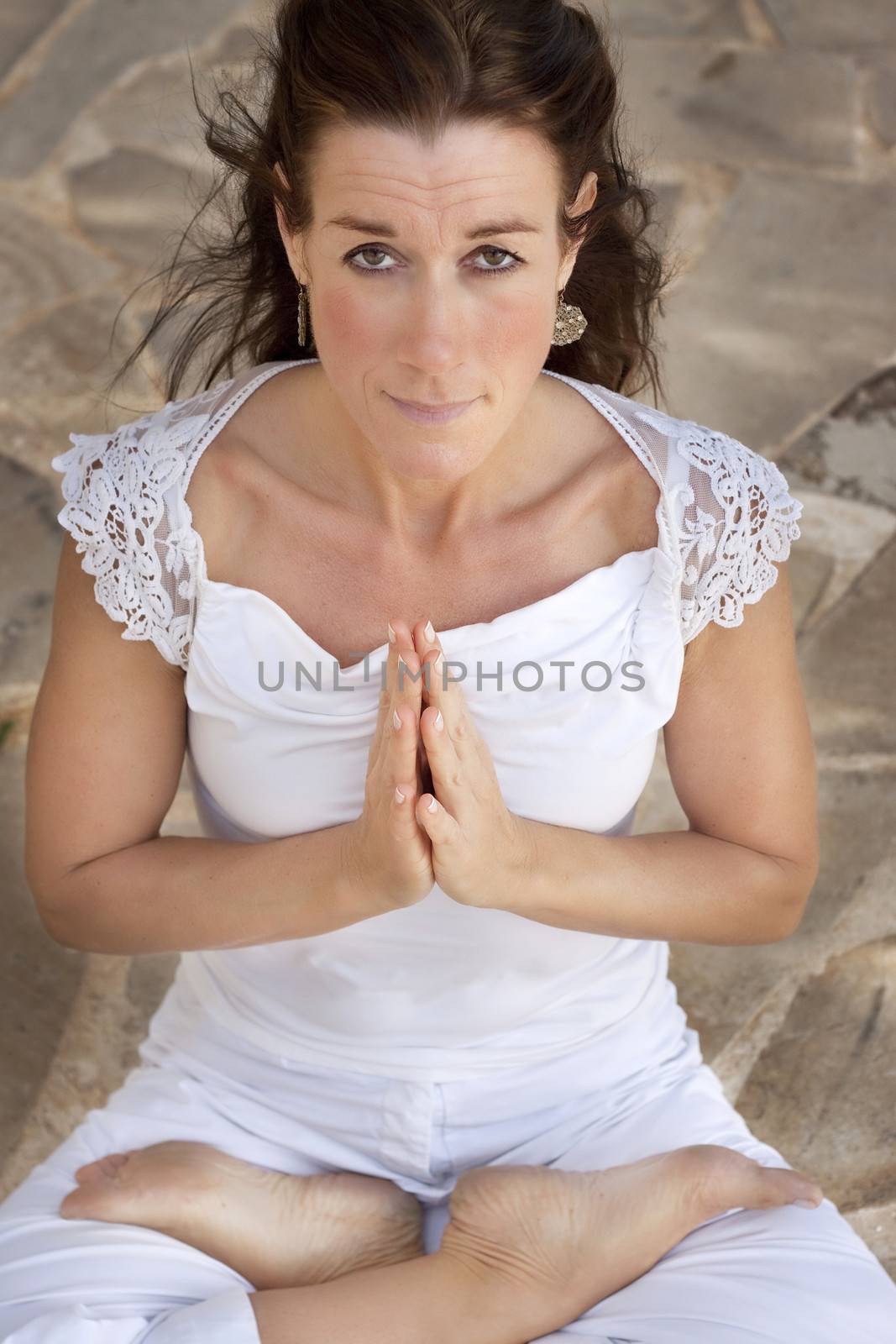 Middle aged woman doing lotus yoga position by annems