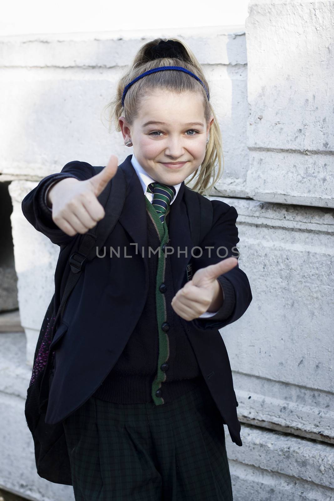 School girl with uniform doing thumbs up, positive feeling