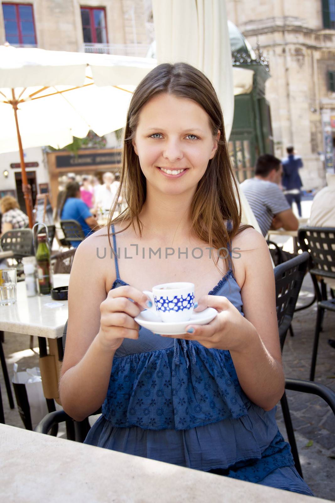 Woman drinking coffee in outdoor cafe by annems