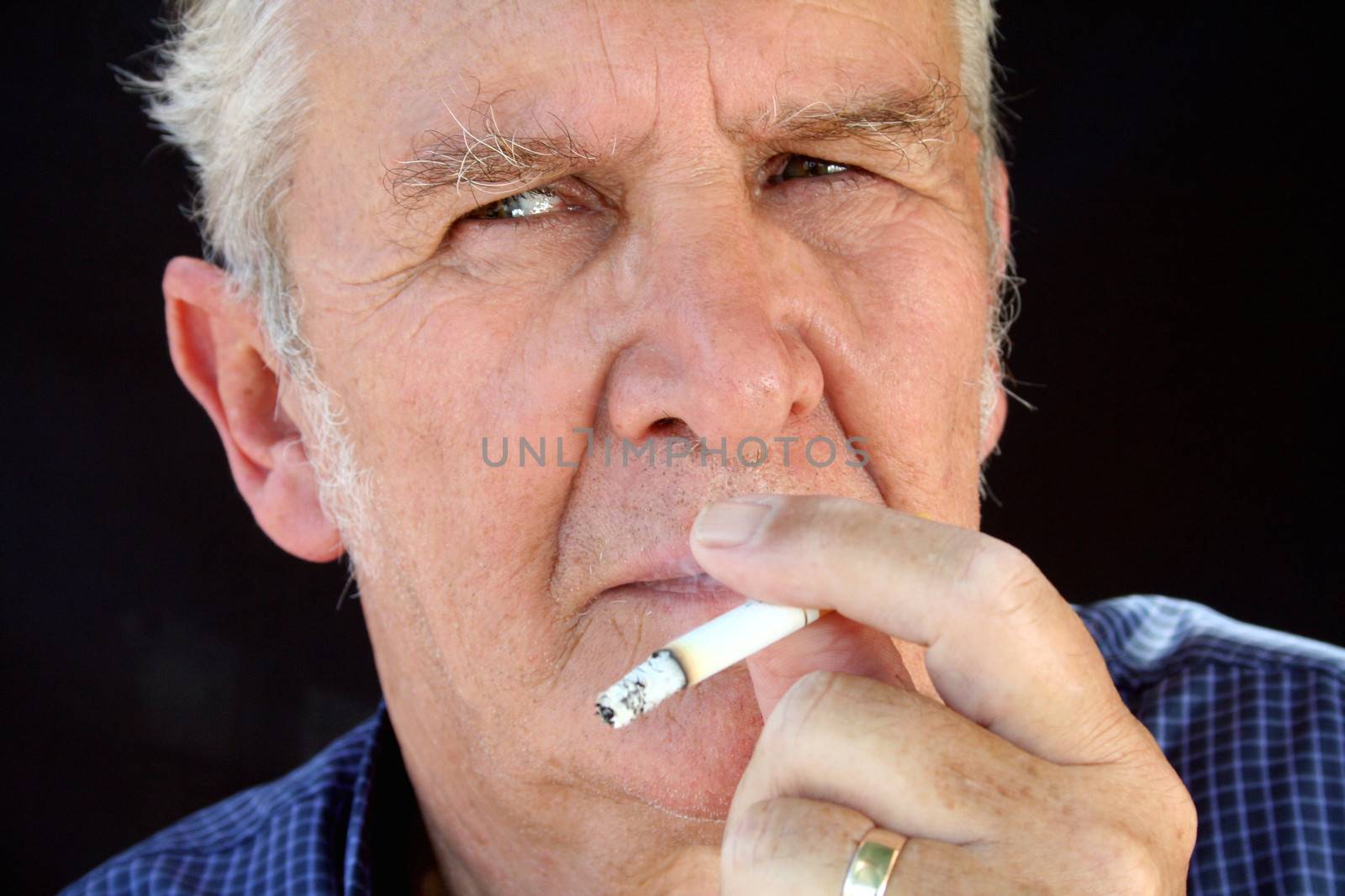 Senior smoking with tough guy look.