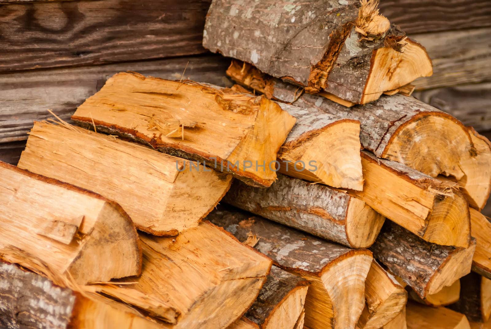 chopped fire wood next to log cabin by digidreamgrafix