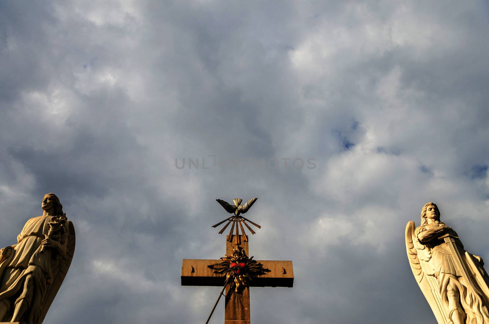 Two angels and a cross with an overcast sky