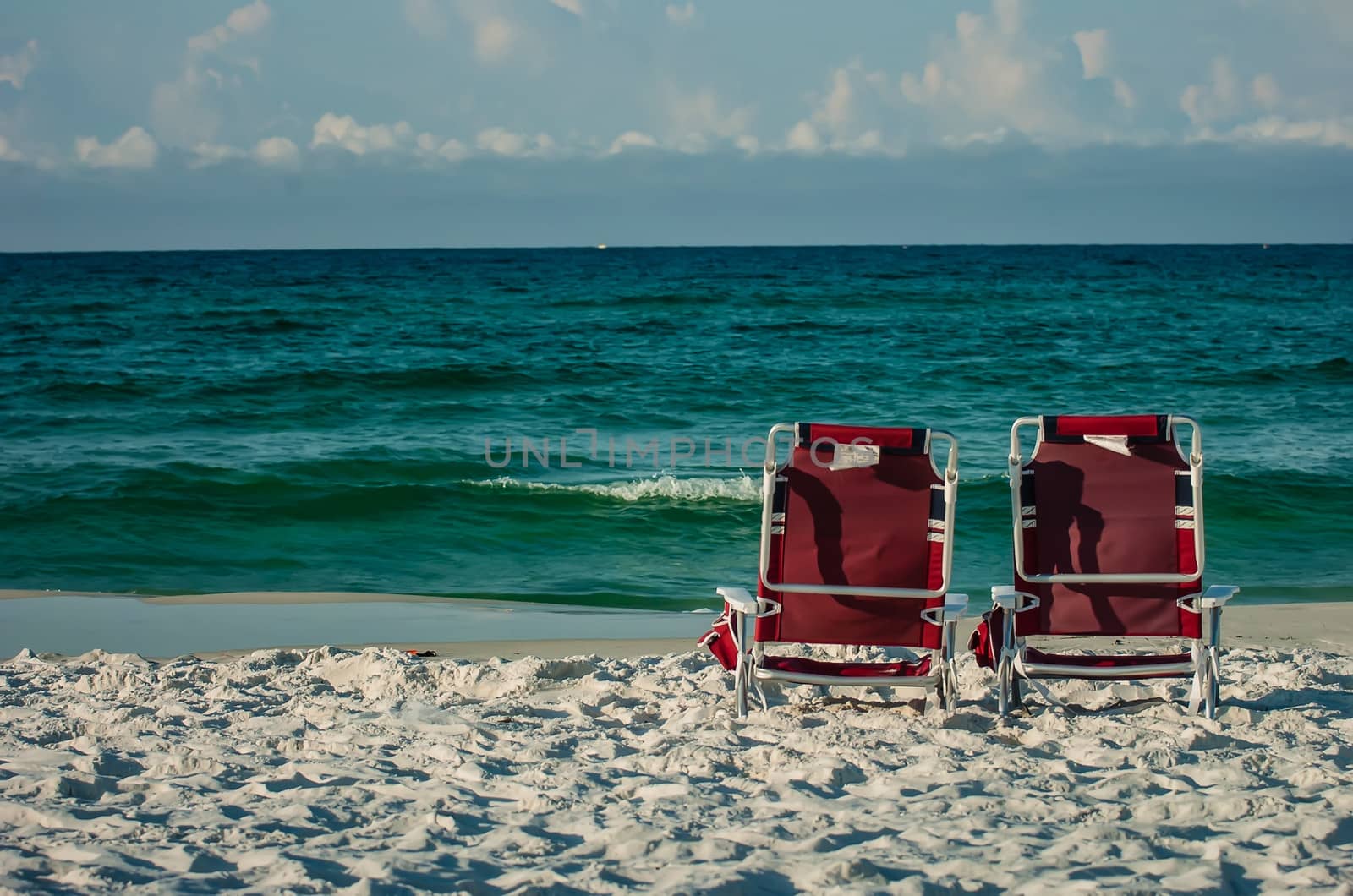 two chairs on a beach with gulf of mexico background