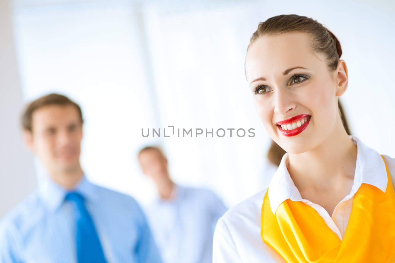 Portrait of a young successful business woman standing against colleagues