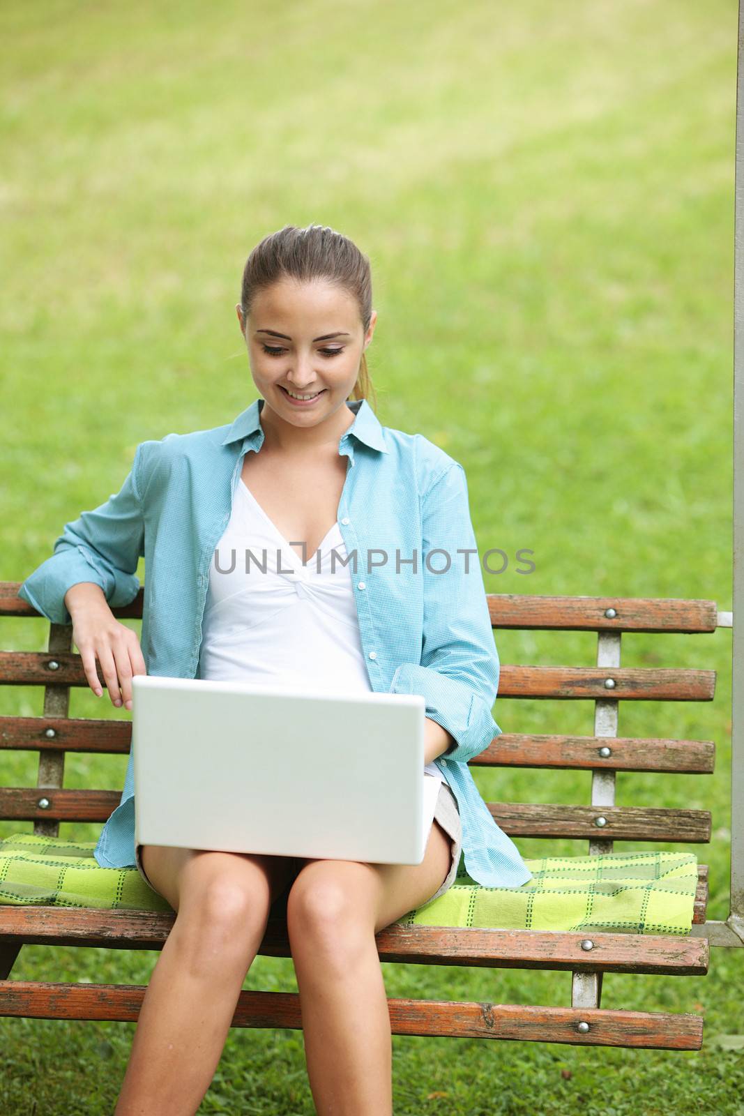 Cheerful girl working in laptop outdoors in a sunny day