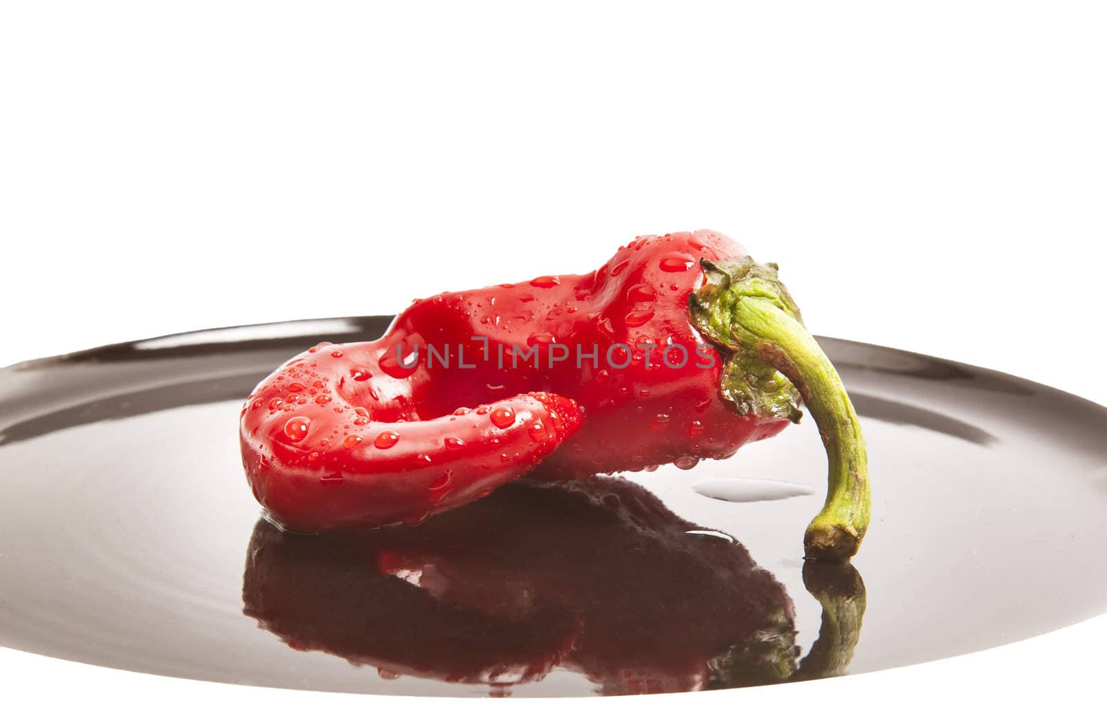 Red fresh chili pepper on black plate