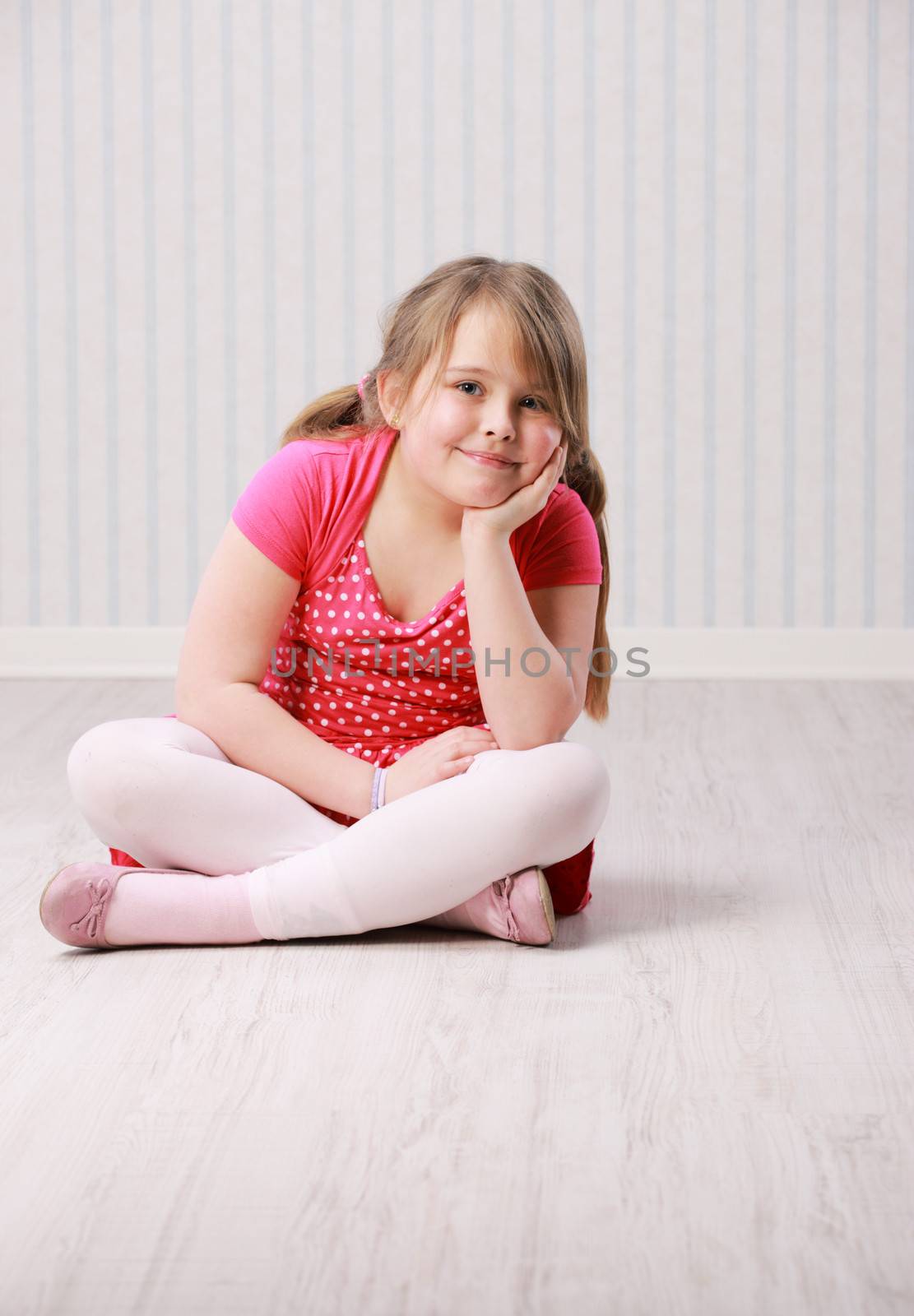 Portrait of a little beautiful girl sitting on floor