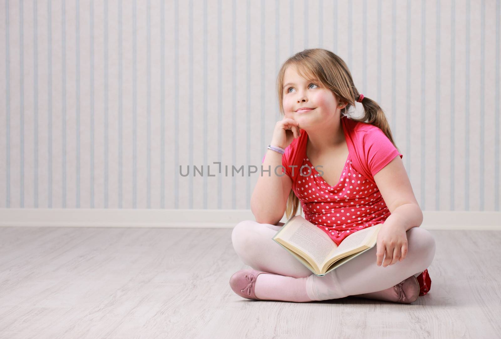 Portrait of a smiling little beautiful girl with book