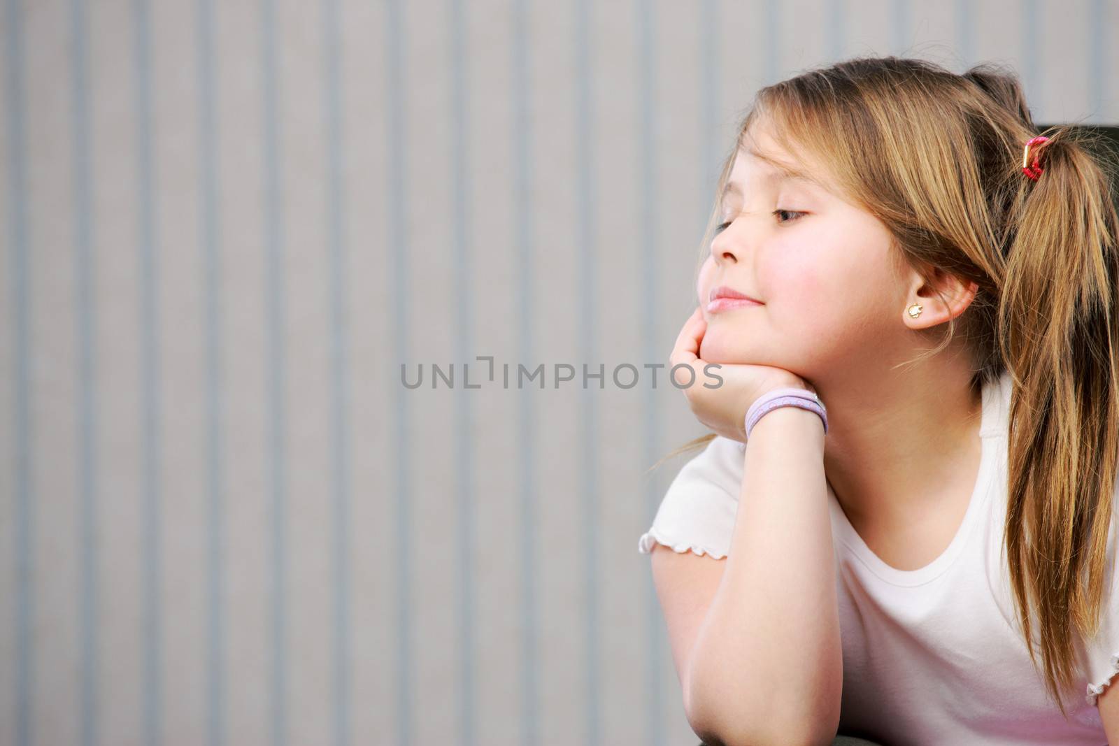 Portrait of a little beautiful girl looking at copy space