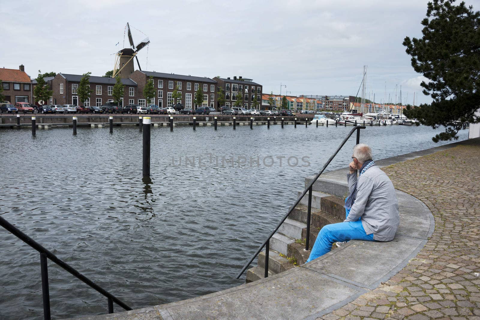 man sitting on the strairs to the water and thinking
