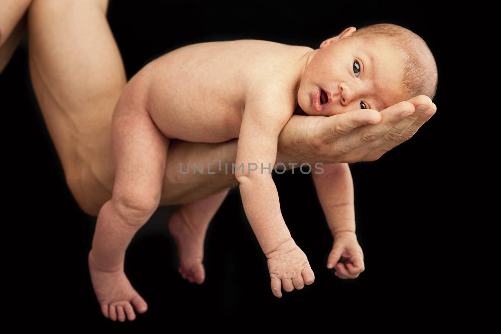 Newborn boy lying on his dad's arm by photobac