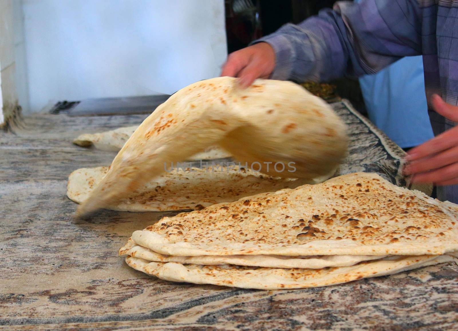 arab baker making arabic bread .