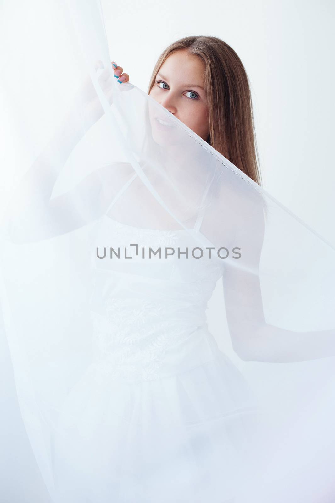 beautiful girl in a white body plays with tulle