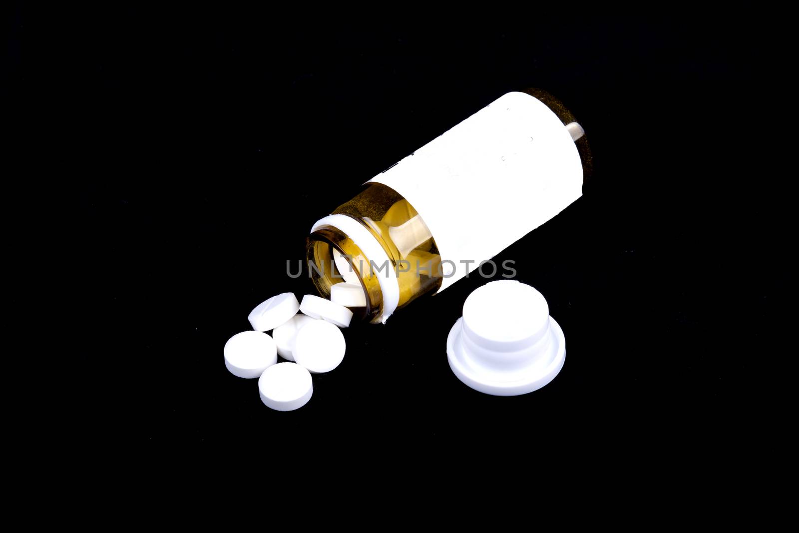 Suplements pills on the table with dose isolated on a black background