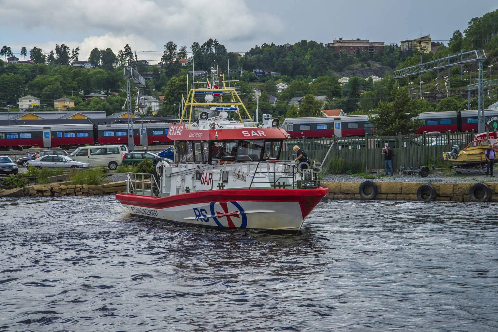 Rescue boat RS 142, Horn Flyer escorts MS Sj��kurs with NRK through Ringdalsfjord, heading for the port of Halden. Photo is shot from Halden harbor, Halden, Norway.