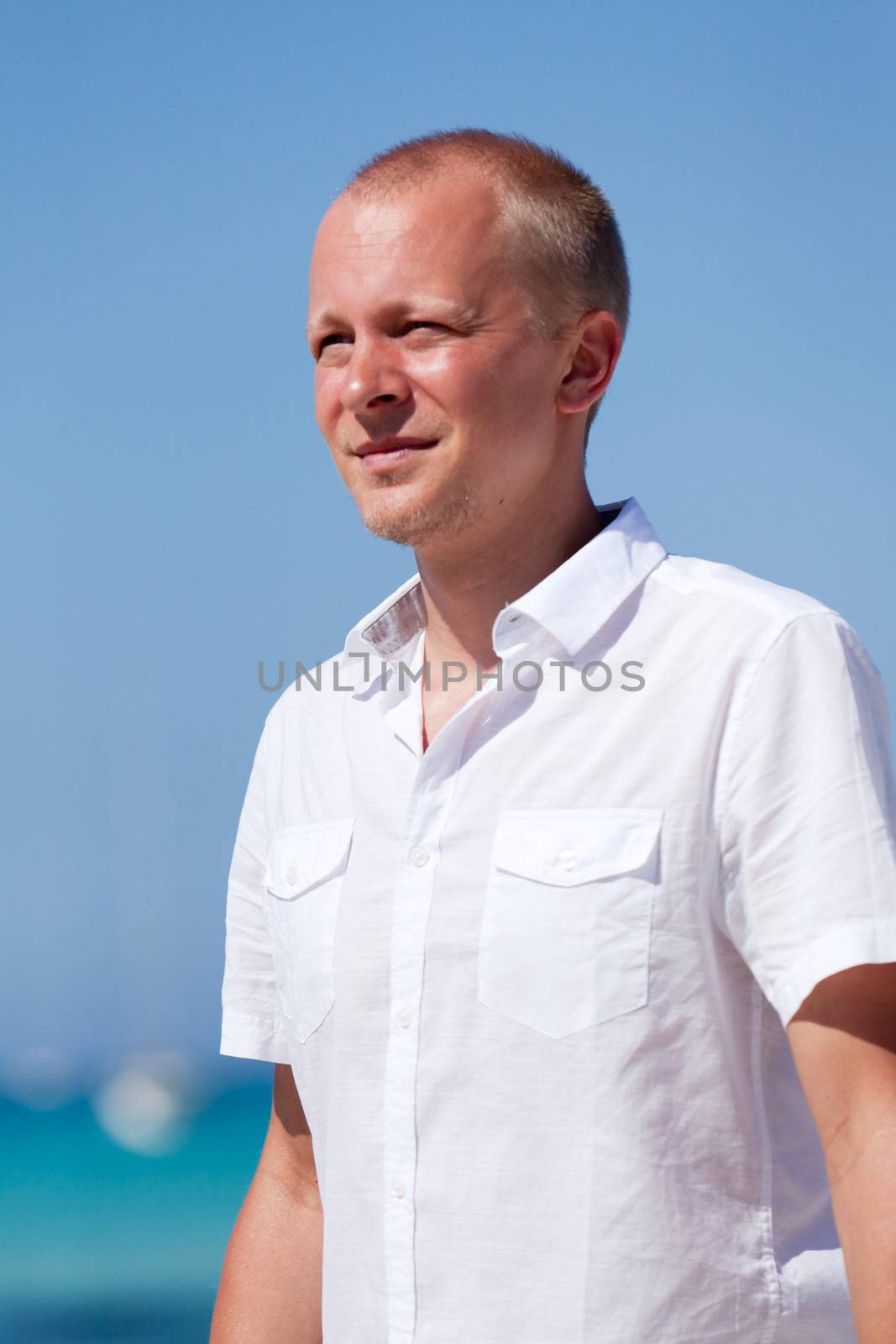 young man walking on the beach in summer holiday vacation