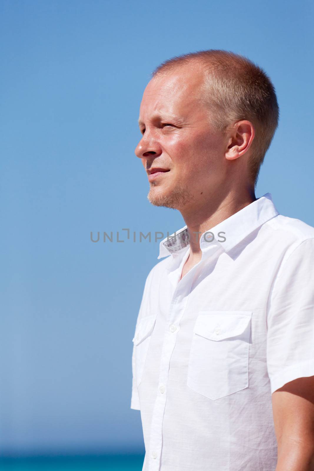 young man walking on the beach in summer holiday vacation