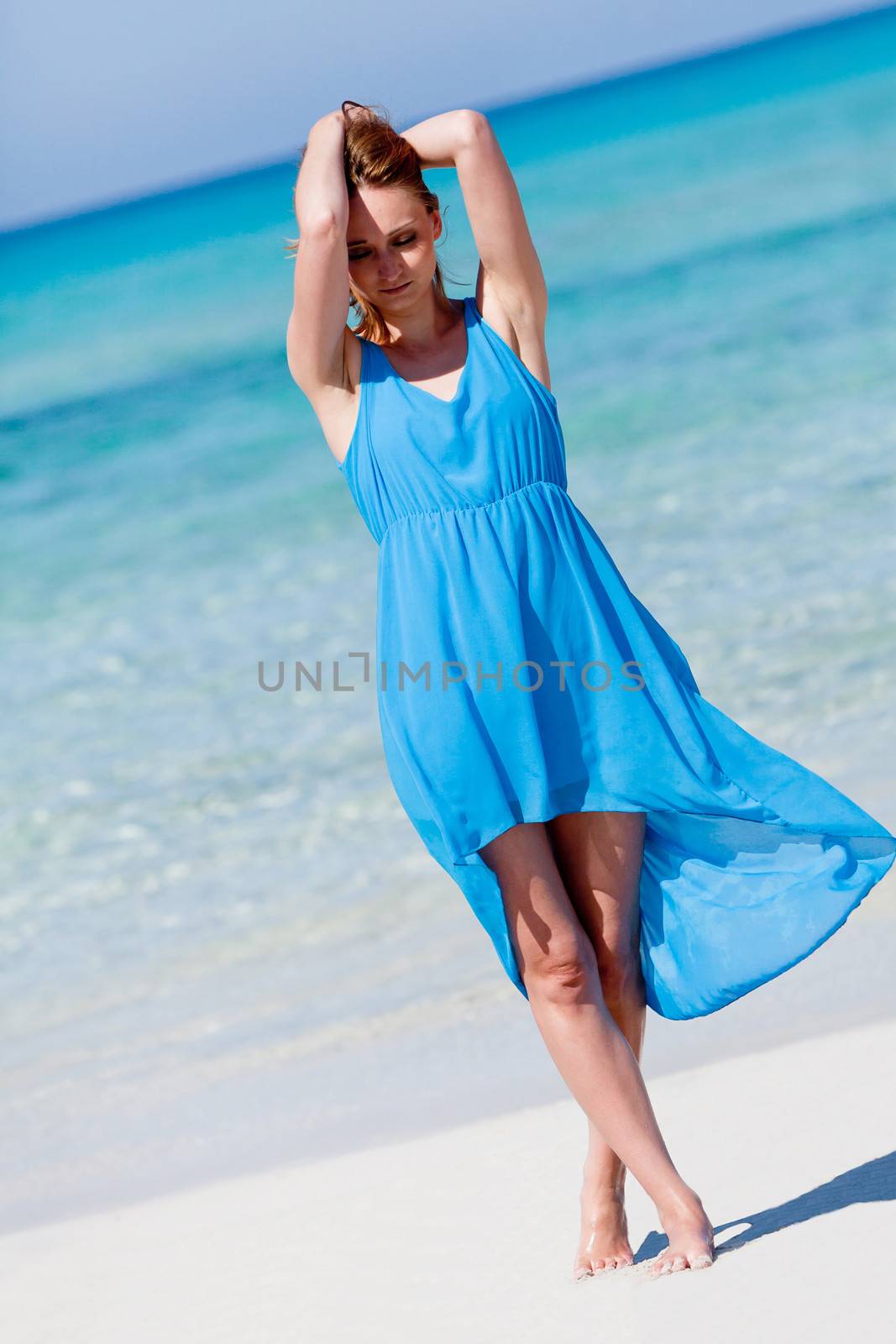beautiful woman in blue dress on beach in summer holiday carefree