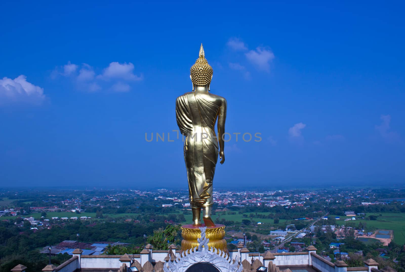 Black golden buddha statue against blue sky in thai temple