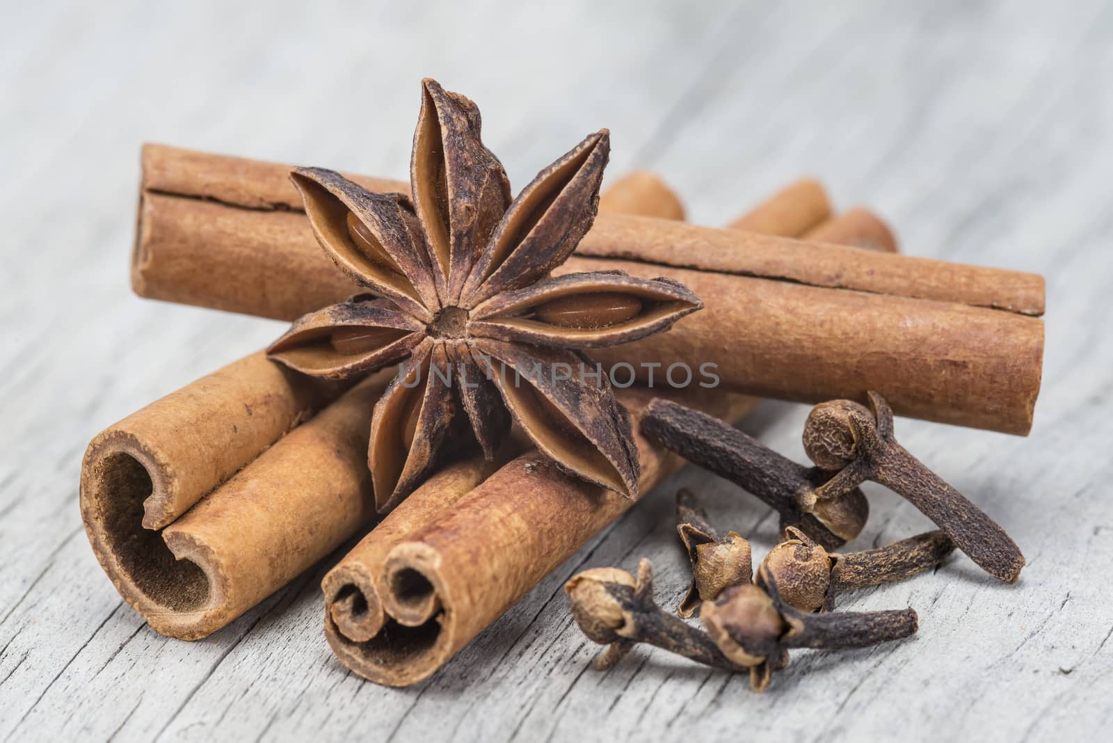Cinnamon with anise and clove over wood by angelsimon