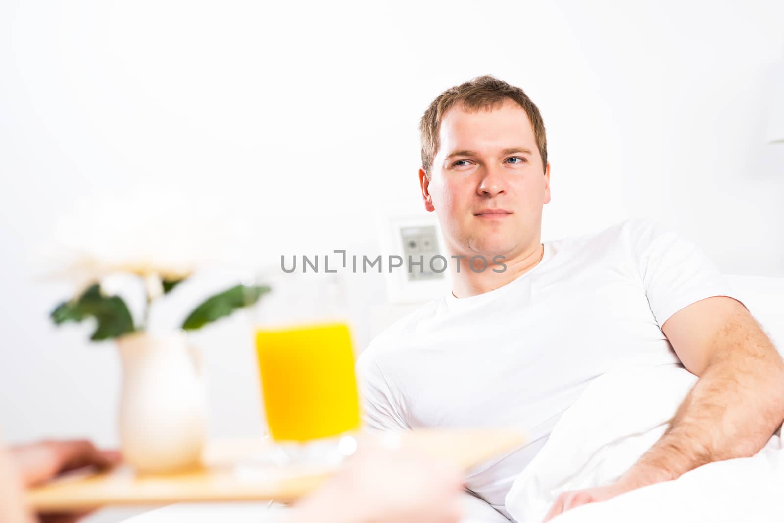 woman brought her boyfriend breakfast in bed, holding a tray of juice and breakfast