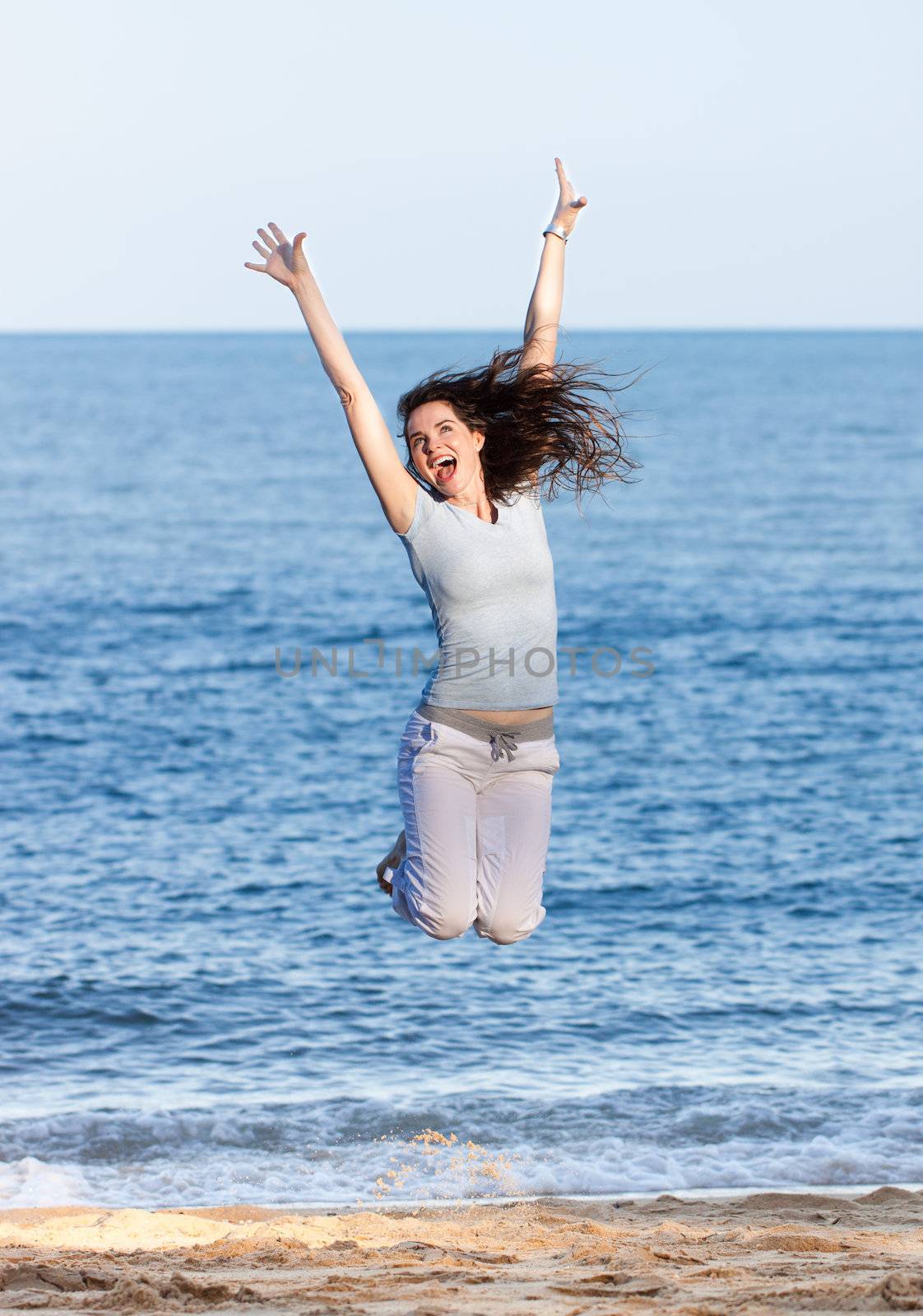Woman jumping on a beach by Jaykayl