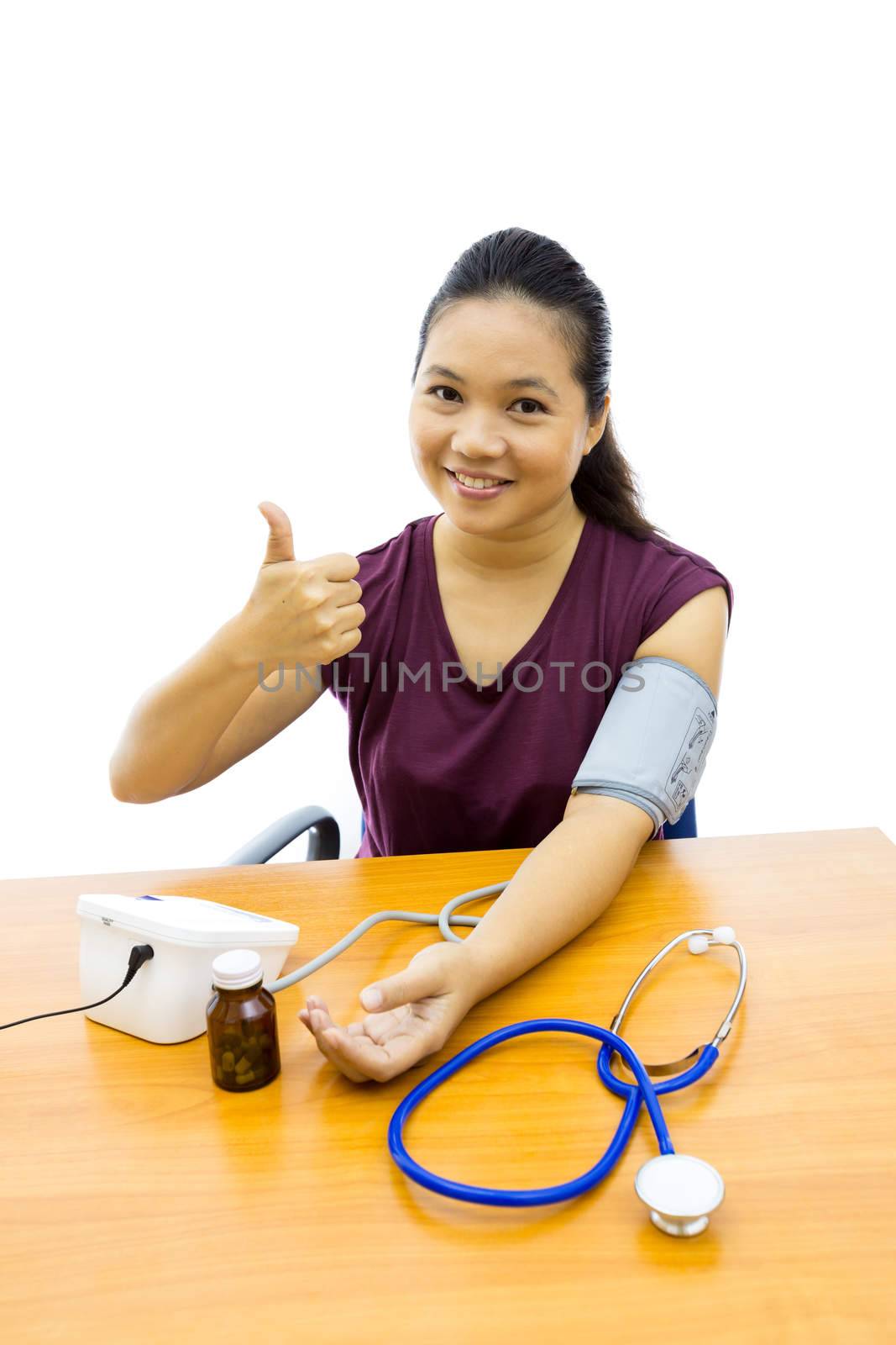 Young adulte woman happy with her self blood pressure test (Selective focus at woman)