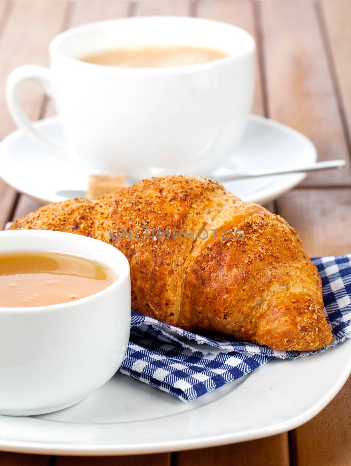 Croissant with marmalade  and caffee cup. on wooden backgroun by motorolka