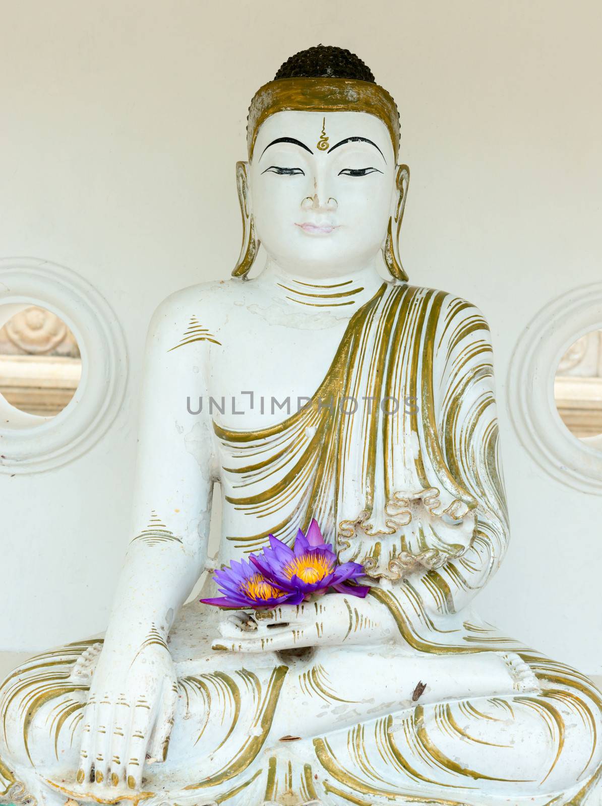 Buddha image statue with fresh flowers in hands by iryna_rasko