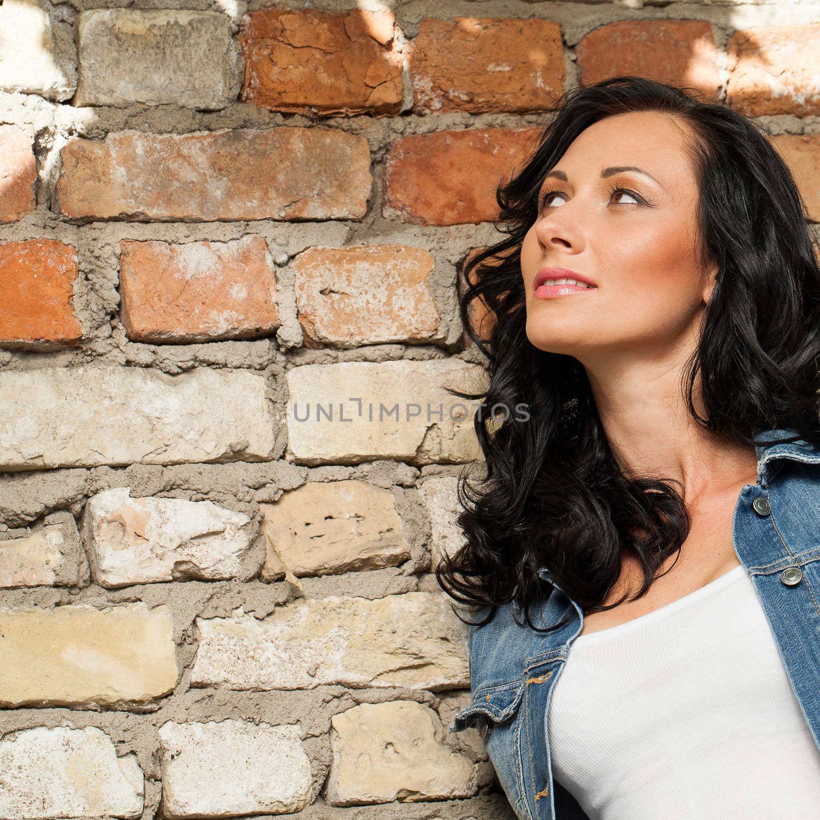 Beautiful young caucasian woman at the brick wall