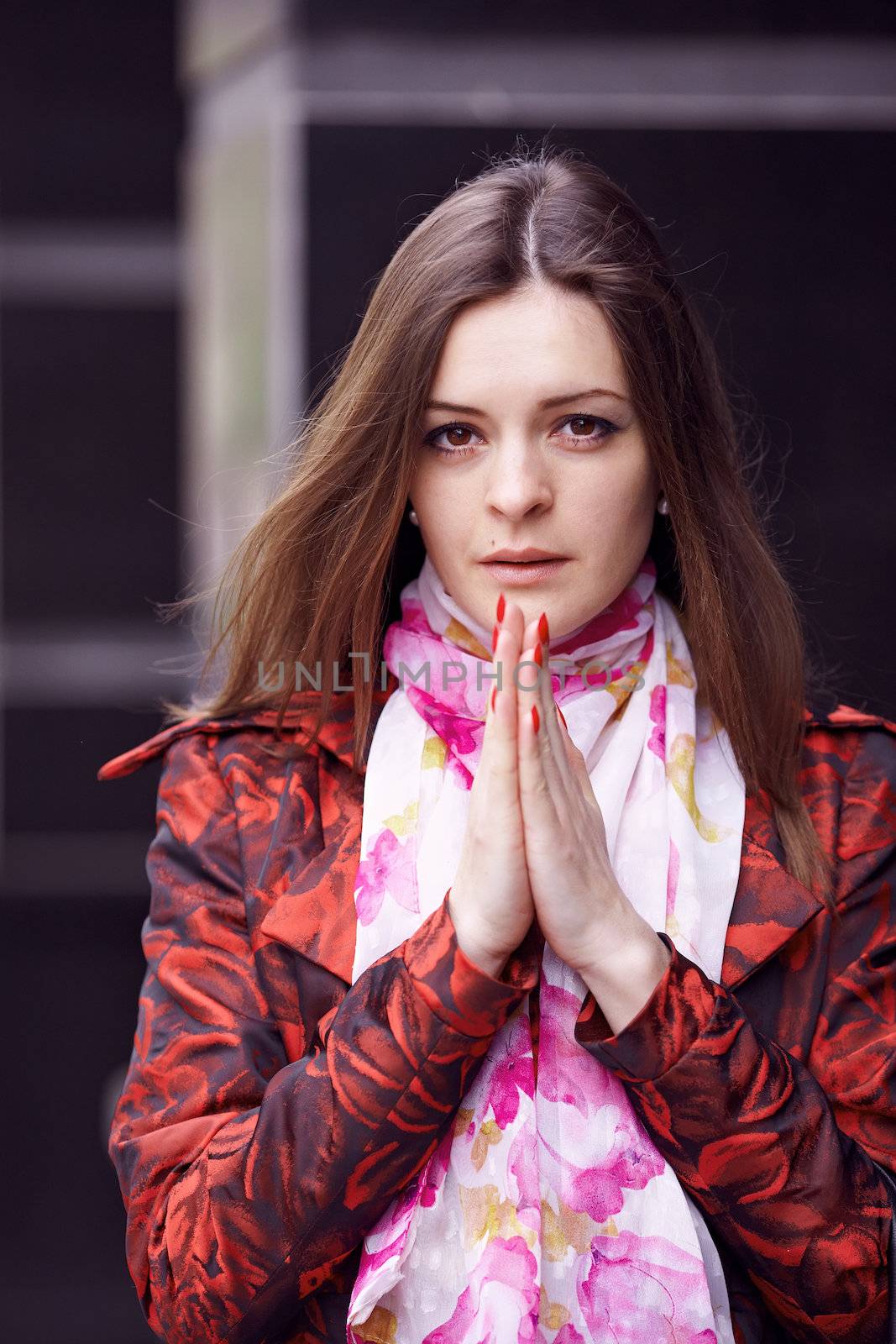 Beautiful girl in a red cloak praying